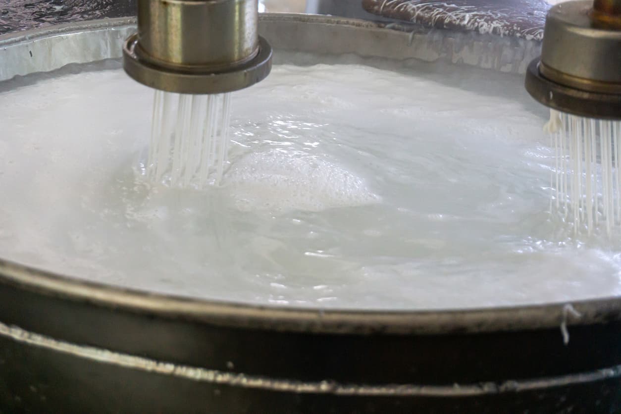 Proceso de producción de líquido espumoso en un tanque, con tubos de salida visibles.